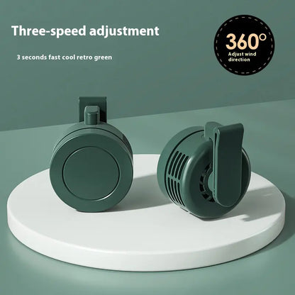 Two green fans on a white platform with text about three-speed adjustment and 360-degree wind direction.